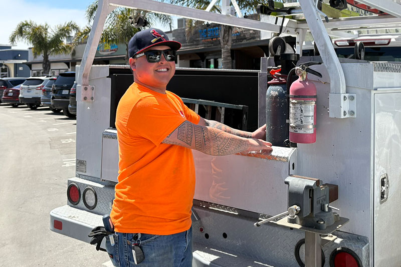 employee smiling next to truck